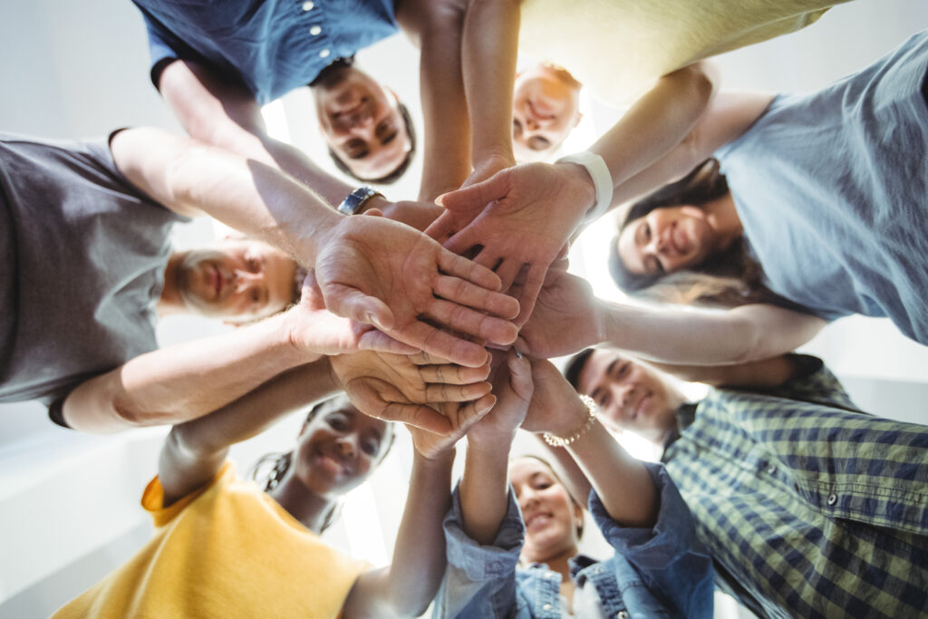 diversidad de personas uniendo sus manos en circulo dando idea de equidad de género